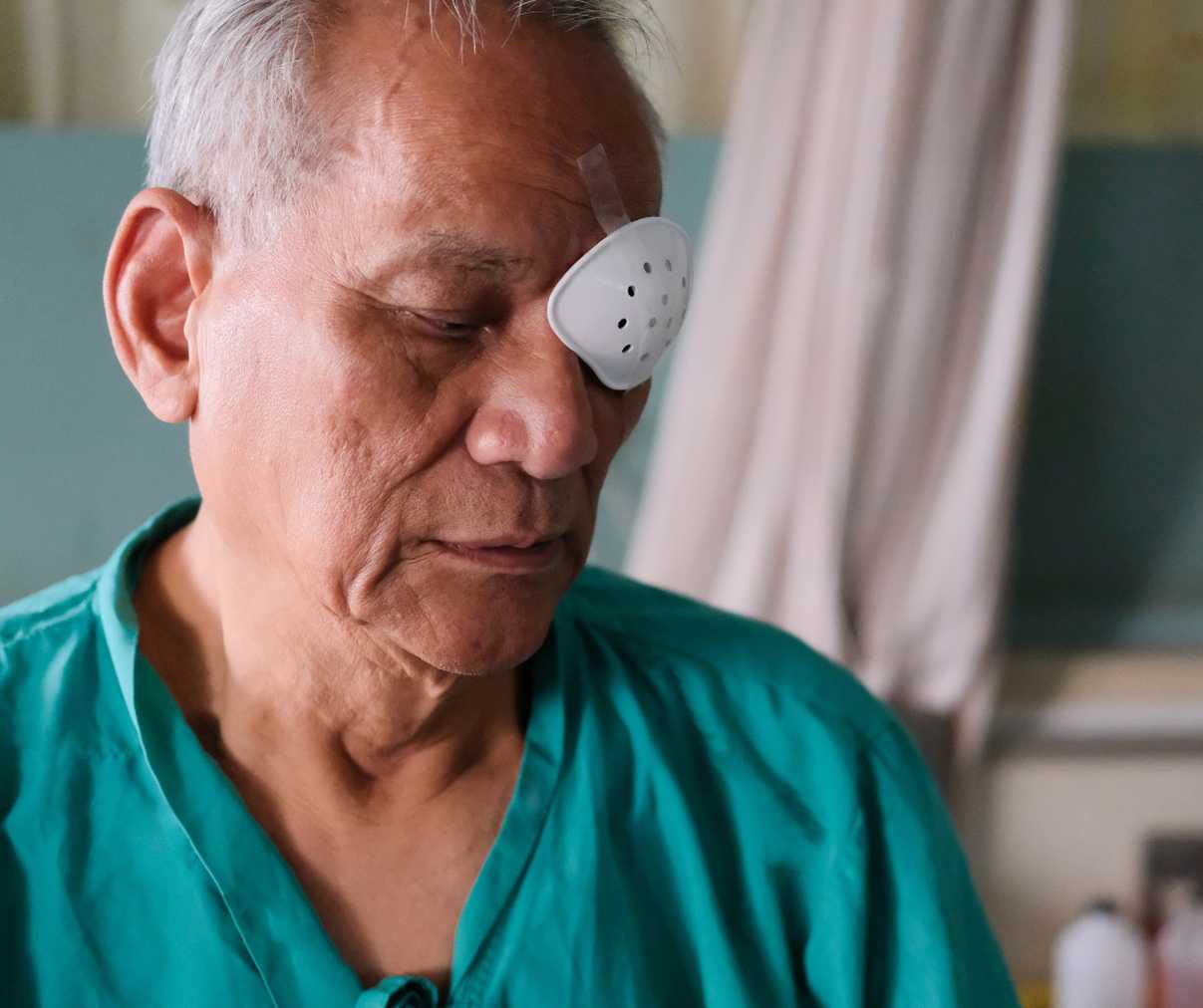An elderly man with an eye covering post operation