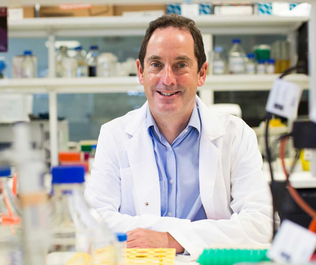 A researcher sat smiling within a labatory